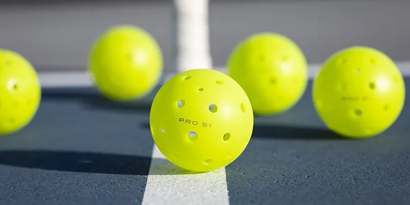 Selkirk neon yellow pickeballs on court